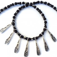 7 silver-plated Pendants showing Kokopelli. The Anasazi , a people in the southwest of the USA, believe in the healing and protective power of Kokopelli; small black and white Trade Beads, Murano, Italy ;Lavalength: 45 cm, weight: 30 g, prize: € 115.-
