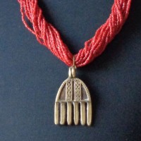 Old brass Pendant of the Dogon, Mali, and several strands of red Seed Beads, Nepal length: 71 cm + 5,5 cm pendan, weight: 147 g, prize: € 150.-